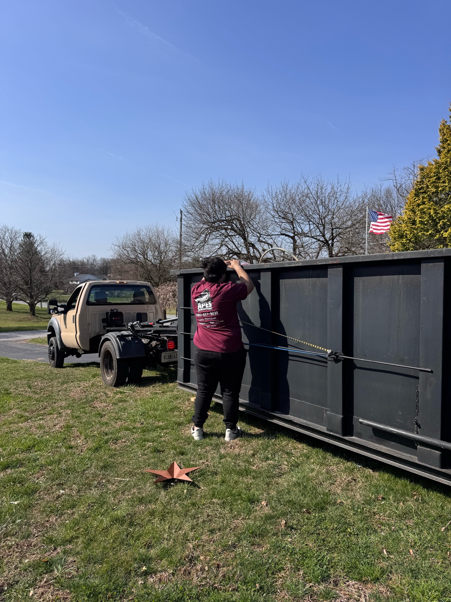 APES Demolitions team member with 15-yard roll-off dumpster